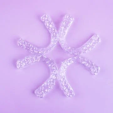 Invisible dental teeth brackets tooth aligners on pink background. Plastic .. Stock-Fotos