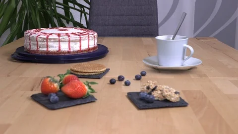 Invisible ghost stirs coffee, cake with cookies stand on the table Stock Footage 124906177