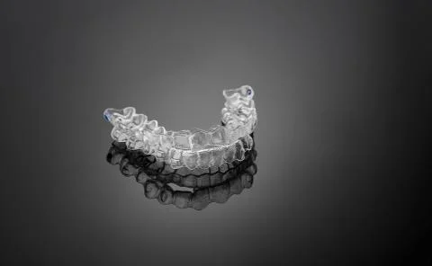 Invisible orthodontics cosmetic brackets on black background, tooth aligners, Stock Photos