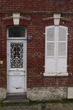 An inviting and charming brick wall that showcases a rustic white door along  Stock Photos