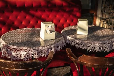 An inviting cafe setting, featuring two tables adorned with decorative lace, set Stock Photos