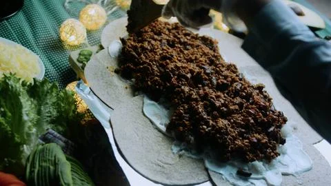 Inviting cooking view: adding lettuce over seasoned beef Stock Photos
