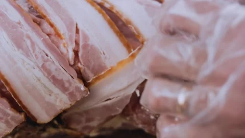 Inviting finished dish: arranging bacon strips under stuffed pork Stock Footage 342184684