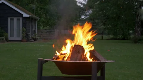 Inviting Fire Pit BBQ with burning wood and ember surrounded by trees Stock Footage 144155197