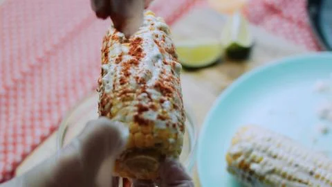 Inviting food study: pressing white cheese over a corn cob Foto stock