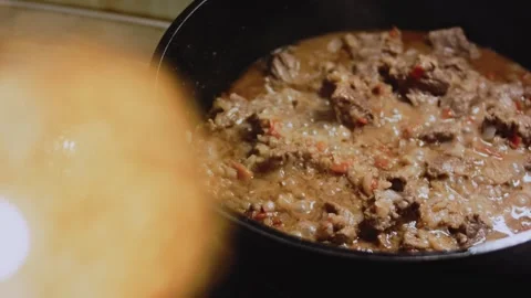 Inviting food styling scene: stirring tomato into the beef mixture Video stock 342199589