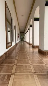 Inviting Long Hallway with Arched Columns and Tiled Floor 스톡 사진