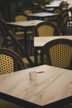 An inviting outdoor cafe setting with empty tables and chairs. A serene outdoor Stock Photos