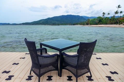 An inviting outdoor seating area with a pristine view of a tranquil beach, .. Stock Photos
