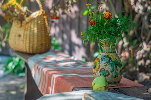 An inviting outdoor setting with rustic elements, a woven table, vase of vi.. 写真素材