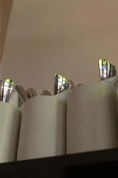 Inviting restaurant setting featuring paper rolls and stainless silverware Stock Photos