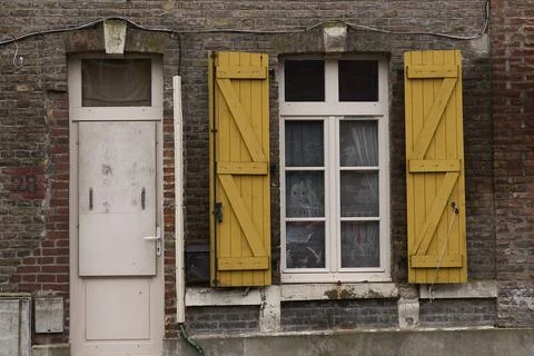 An inviting rusticstyle building with charming yellow shutters and a beautifu Stock Photos