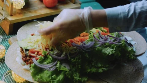 Inviting serving view: adding shredded cheese to a burrito Stock Footage 342168058