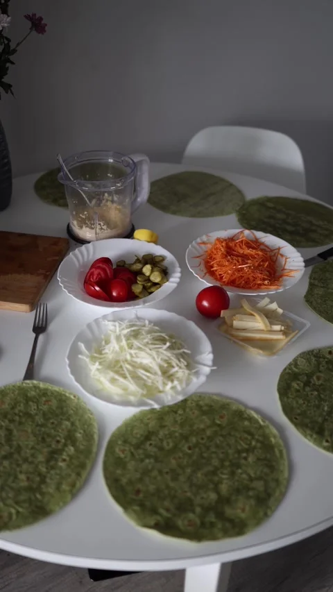 An inviting setup for a healthy meal preparation with spinach tortillas, fresh v Stock Footage 290187140