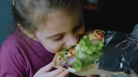 Inviting tabletop view: girl smiling beside a giant burrito Stock Footage 342168415