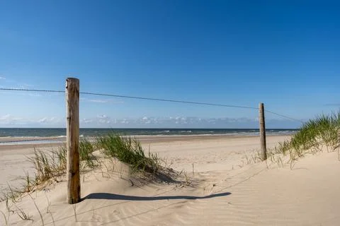 An inviting view of a classic beach access point, featuring a sandy path fram Stock Photos