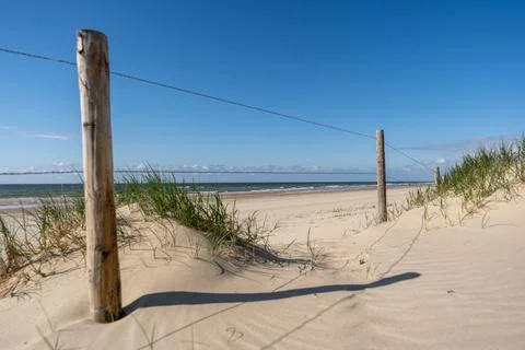 An inviting view of a classic beach access point, featuring a sandy path fram Stock Photos