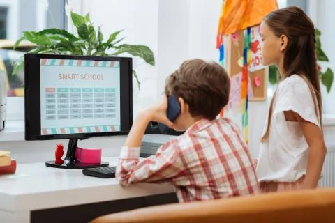 Involved classmates sitting next to the computer Foto stock