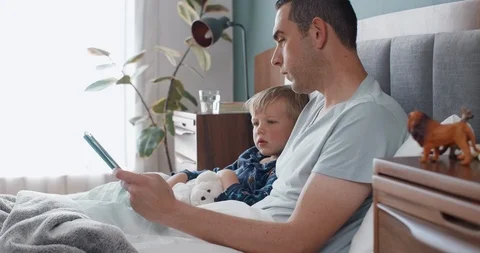 Involved dad reading books to boy Stock Footage 120293142