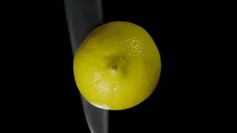 Iolated lemon cut with a knife in the studio on a black background Stock Footage 97123520
