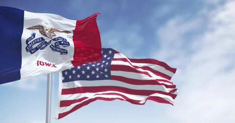 Iowa state flag waving in the wind with the US flag on a clear day Stock-Footage 277877338
