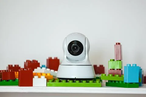 IP camera on the shelf with toys, serving as baby monitor Stock Photos