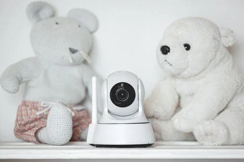 IP camera on the shelf with toys, serving as baby monitor Stock Photos