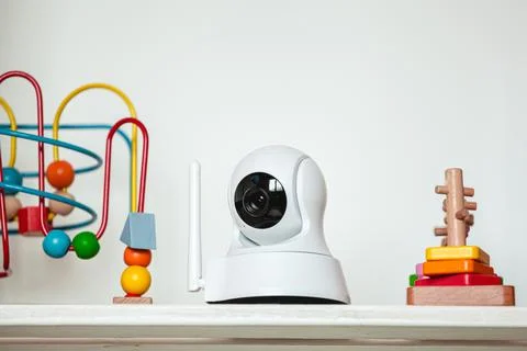 IP camera on the shelf with toys, serving as baby monitor Stock Photos