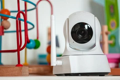 IP camera on the shelf with toys, serving as baby monitor Stock Photos
