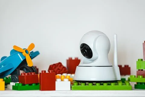 IP camera on the shelf with toys, serving as baby monitor Stock Photos