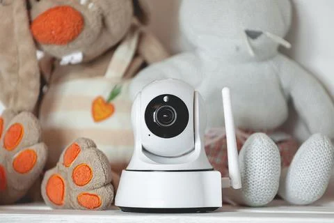 IP camera on the shelf with toys, serving as baby monitor Stock Photos