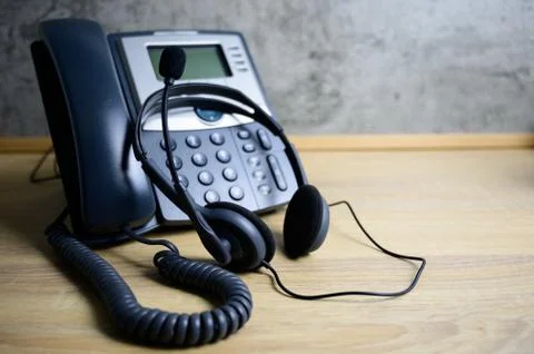IP Telephone and headset on wood table Stock Photos