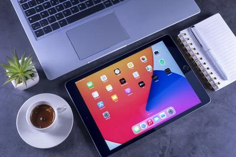 IPad 8th generation with notebook and coffee on desk 库存照片