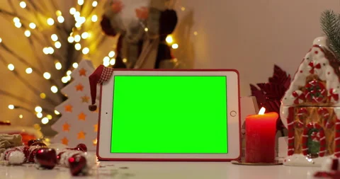 IPad Air tablet with pre-keyed green screen and Santa Claus hat on top standing  Stock Footage 144378463