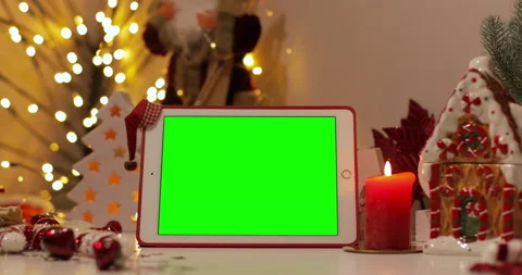 IPad Air tablet with pre-keyed green screen and Santa Claus hat on top standing  Stock Footage 144381006