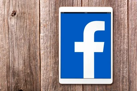 Ipad pro with social network Facebook on the screen, on a wooden table. Stock Photos