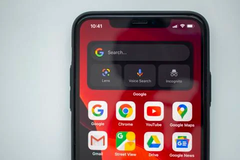 An iPhone 11 pro with Google applications and Widgets on the home screen. Stock Photos