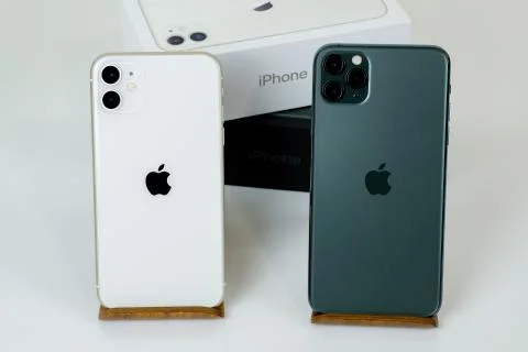 IPhone 11 Pro Max in midnight green color next to iPhone 11 in white. Stock Photos