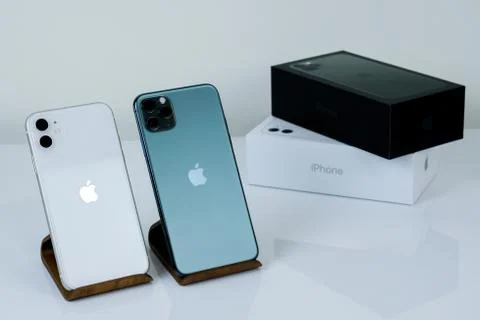 IPhone 11 Pro Max in midnight green color next to iPhone 11 in white. Stock Photos