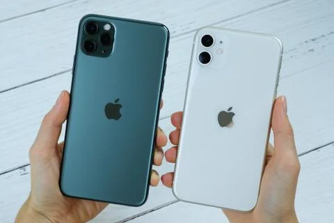 IPhone 11 Pro max in midnight green color next to iPhone 11 in white. Stock Photos
