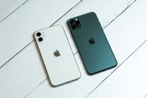 IPhone 11 Pro Max in midnight green color next to iPhone 11 in white. Stock Photos