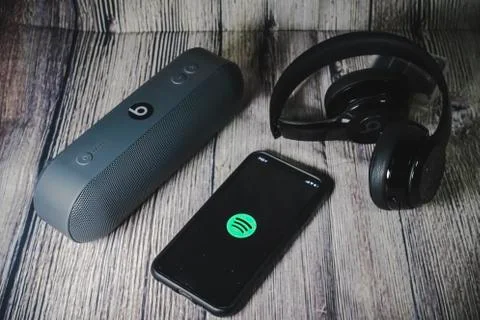 An iphone 11 screen showing spotify icon with beats earphone Stock Photos