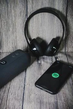 An iphone 11 screen showing spotify icon with beats earphone Stock Photos