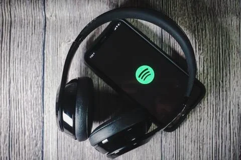 An iphone 11 screen showing spotify icon with beats earphone Stock Photos