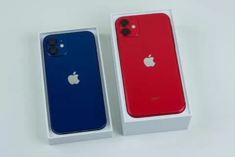 IPhone 12 in blue next to iPhone 11 in red. Stock Photos