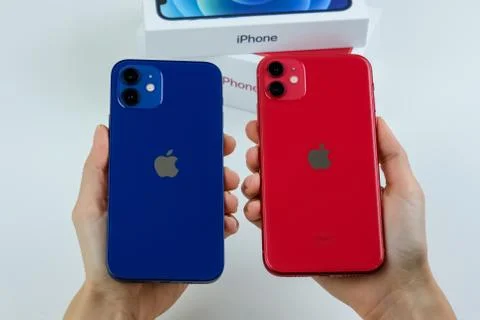 IPhone 12 in blue next to iPhone 11 in red. Stock Photos