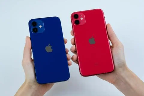 IPhone 12 in blue next to iPhone 11 in red. Stock Photos