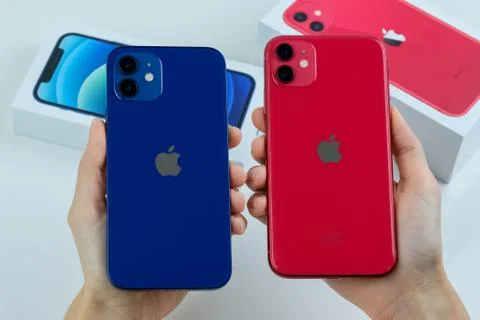 IPhone 12 in blue next to iPhone 11 in red. Stock Photos