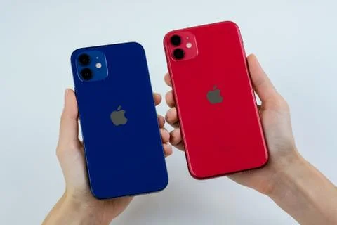 IPhone 12 in blue next to iPhone 11 in red. Stock Photos
