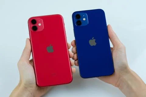 IPhone 12 in blue next to iPhone 11 in red. Stock Photos